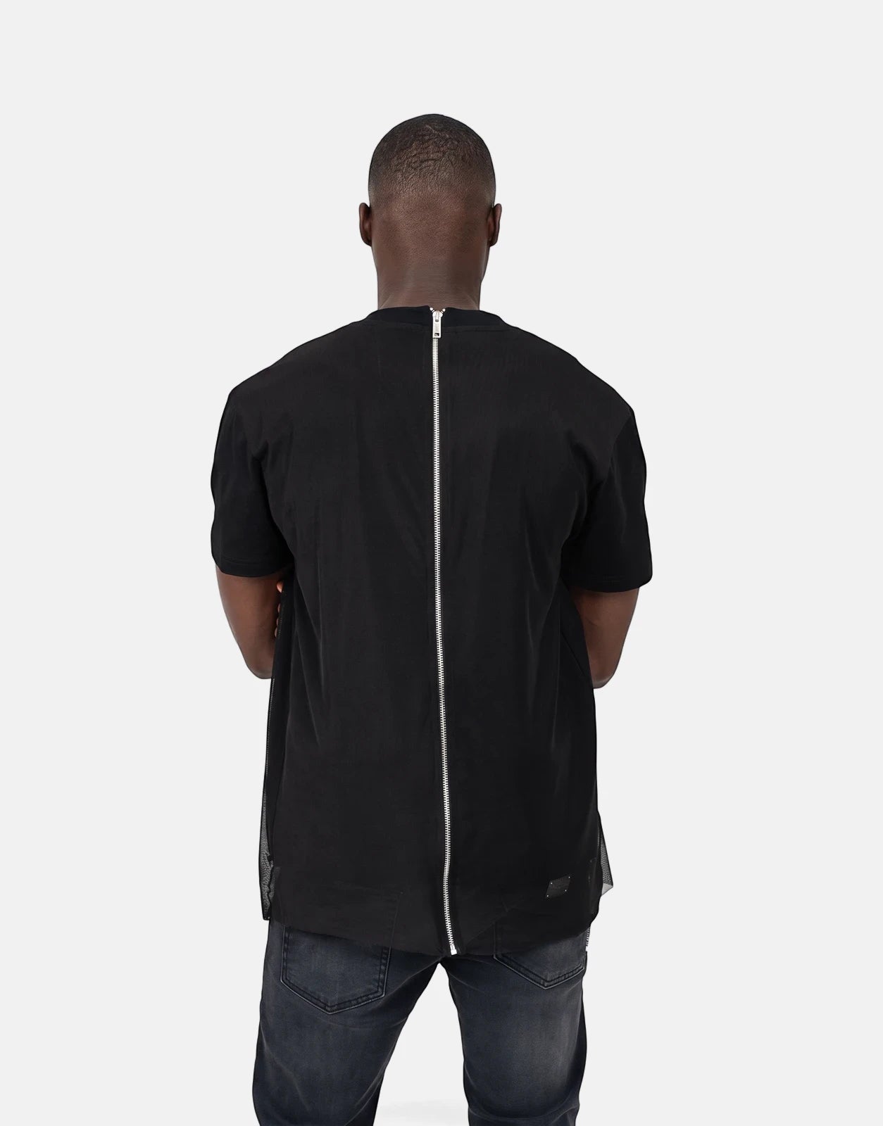 Back view of a man wearing a Les Hommes Tulle Black T-Shirt featuring a full-length silver zipper down the back and mesh