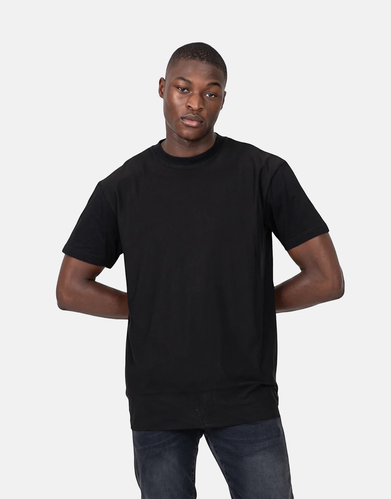 A male model showcases the Les Hommes Tulle Black T-Shirt, a classic short-sleeve crew neck, paired with dark jeans.