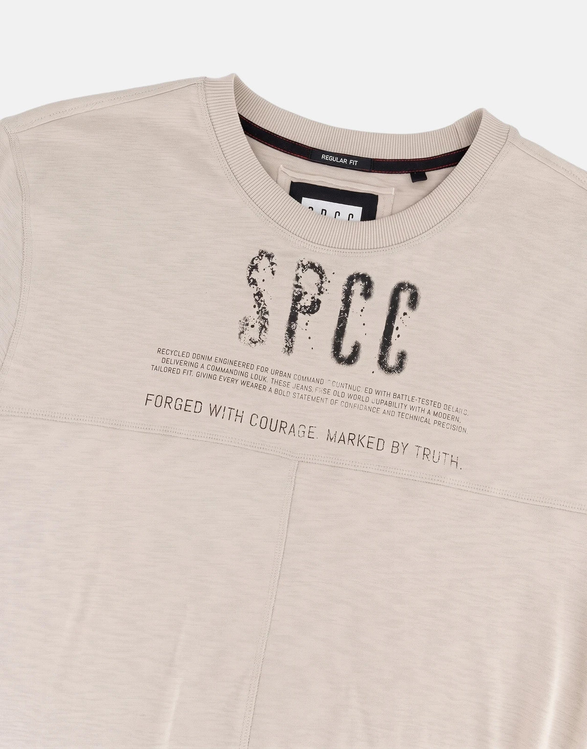 Close-up of a men's beige SPCC Troy crew neck top, showcasing a distressed black SPCC logo print and text details on the
