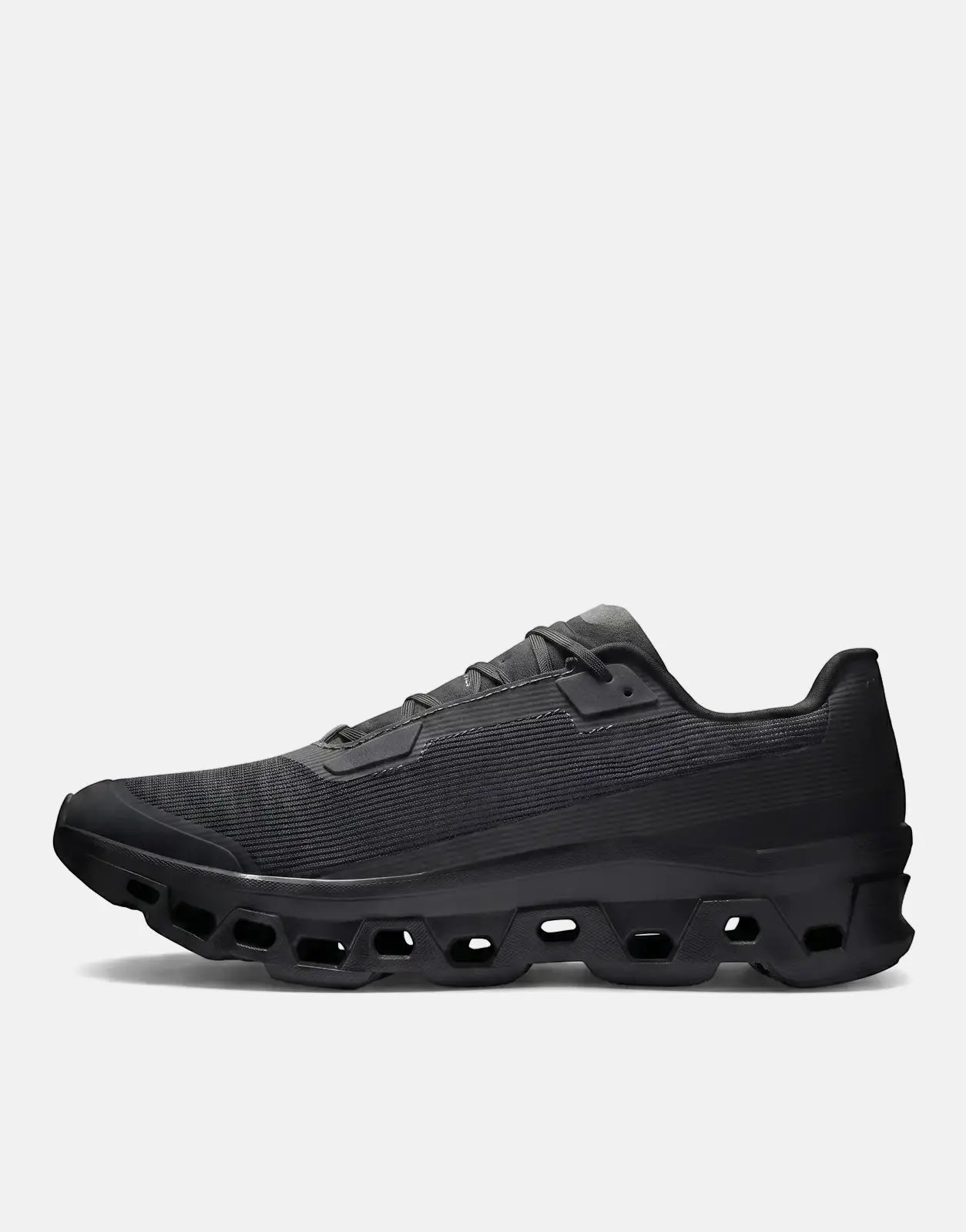 On Men's Cloudmonster Void Black Sneaker, a sleek running shoe with a distinctive CloudTec sole, shown from a side profile