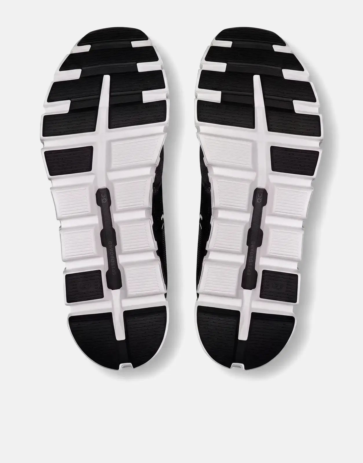 Bottom view of On Women's Cloud 6 sneakers in black and white, showcasing the patterned rubber soles.