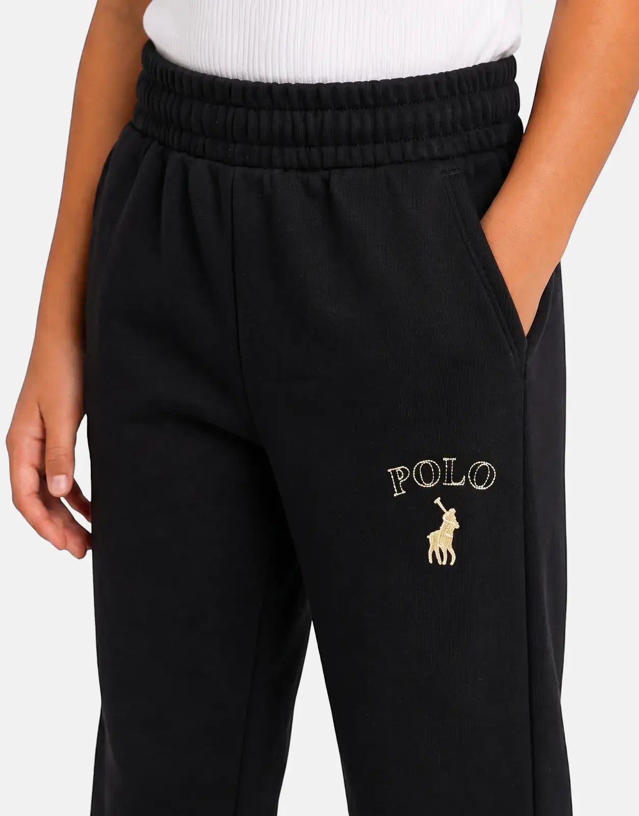 Close-up of Polo Girls Hannah embroidered black joggers, featuring the gold Polo logo on the left leg and elastic waistband.