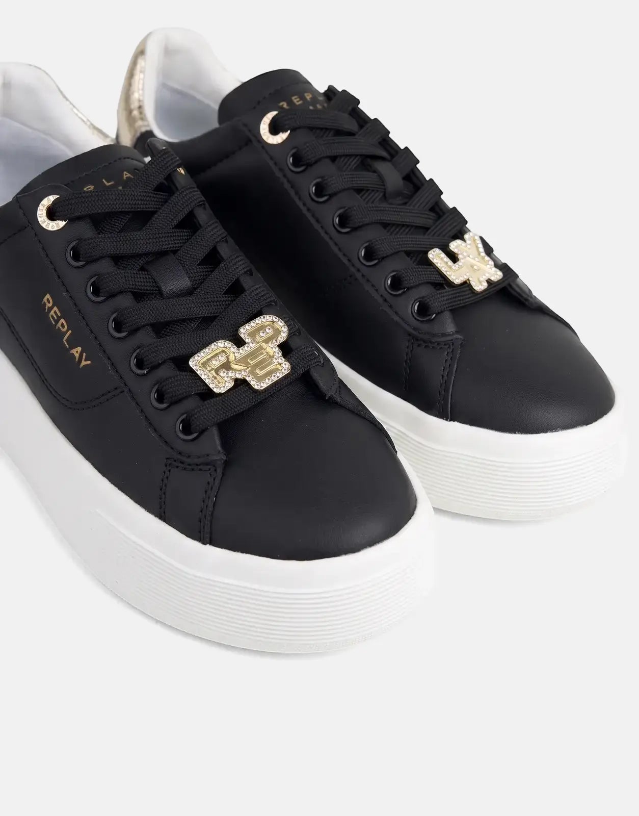 Close-up of Replay Notting W Image black sneakers with white platform soles, gold eyelets, and crystal-studded charms on the