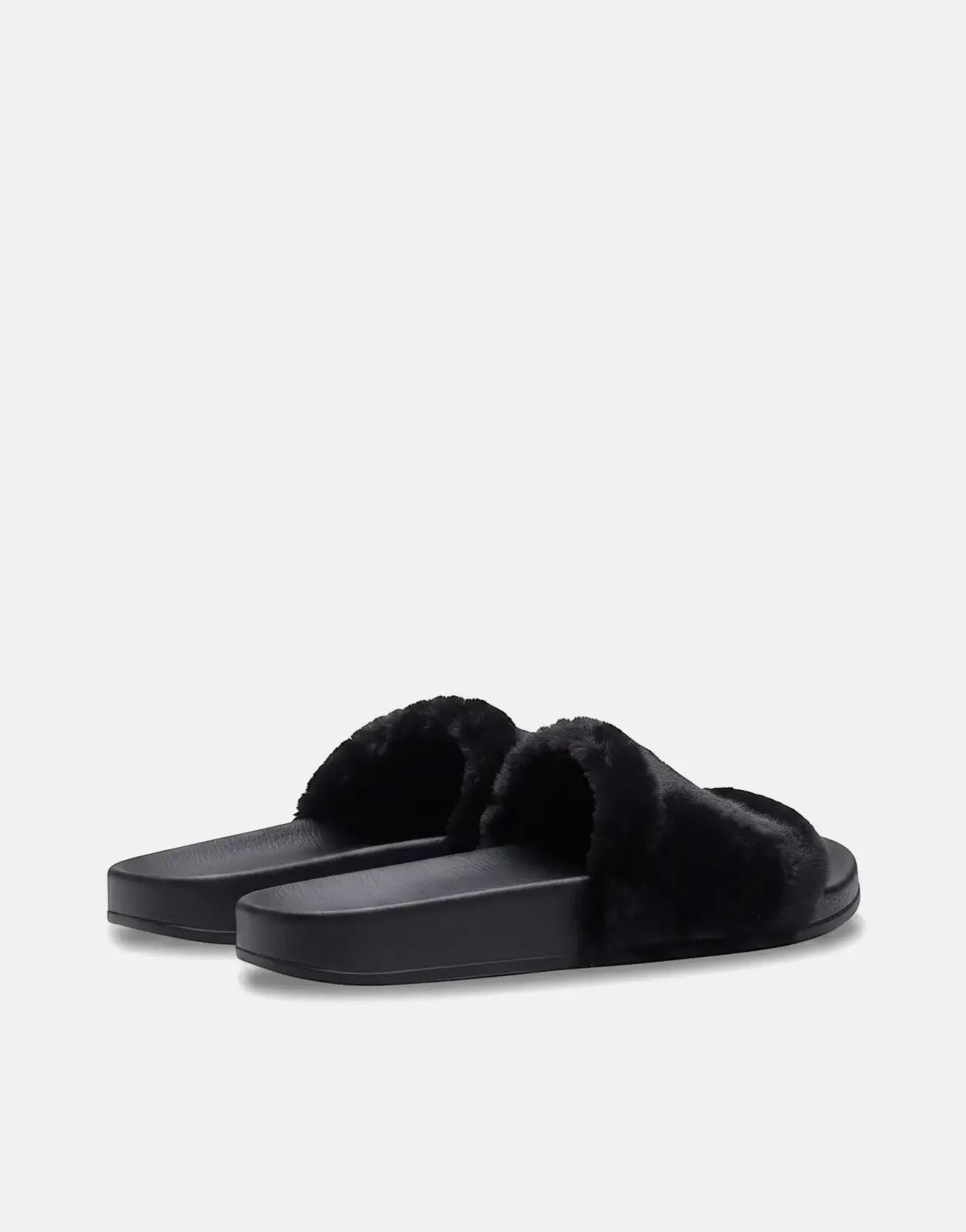 A pair of Replay Up W Along black fluffy slides with a solid sole, positioned on a light gray background.