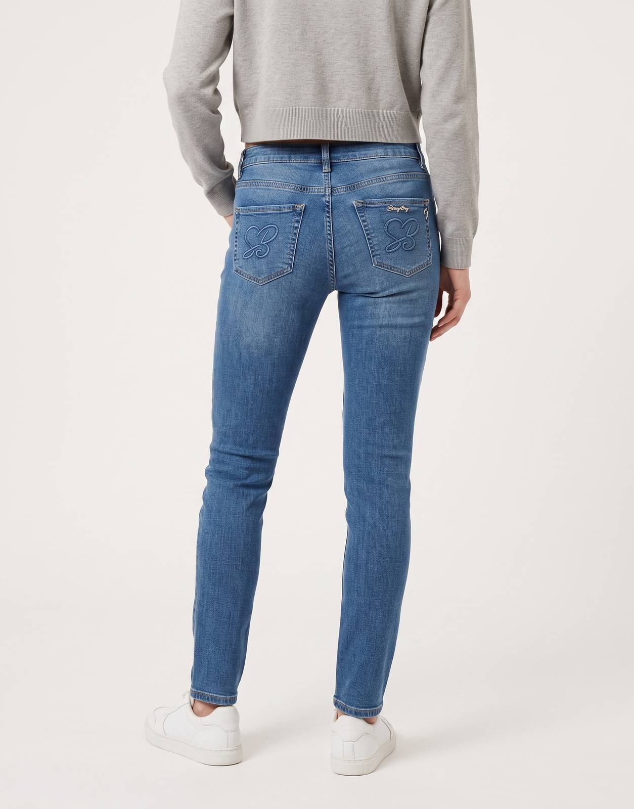 A pair of Sissy Boy Elana Skinny Jeans in blue denim, featuring embroidered back pockets, photographed from the rear view.