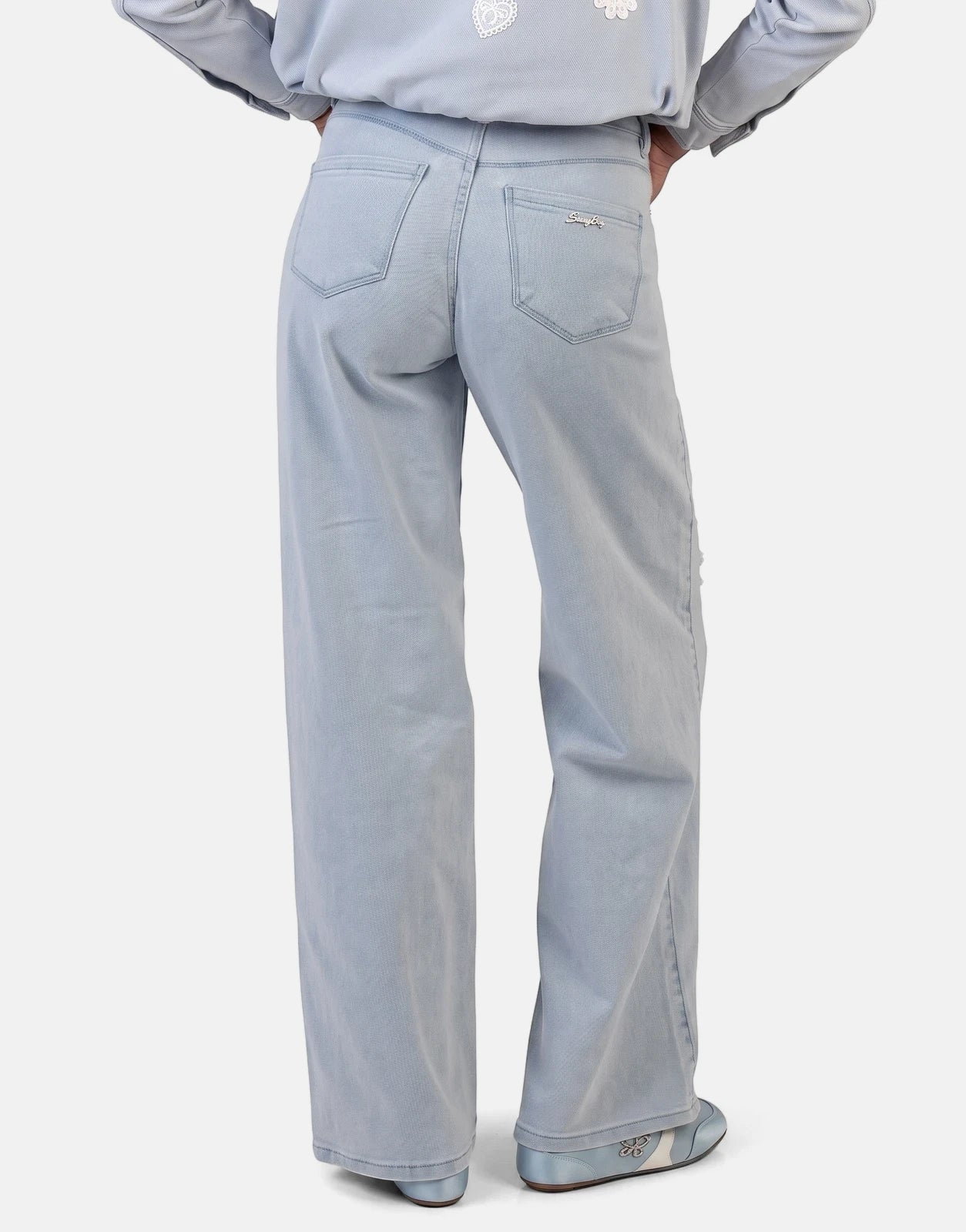 Sissy Boy Kiera Wide Leg Light Vintage Jeans worn by a model from behind, showcasing the light wash and wide leg fit.