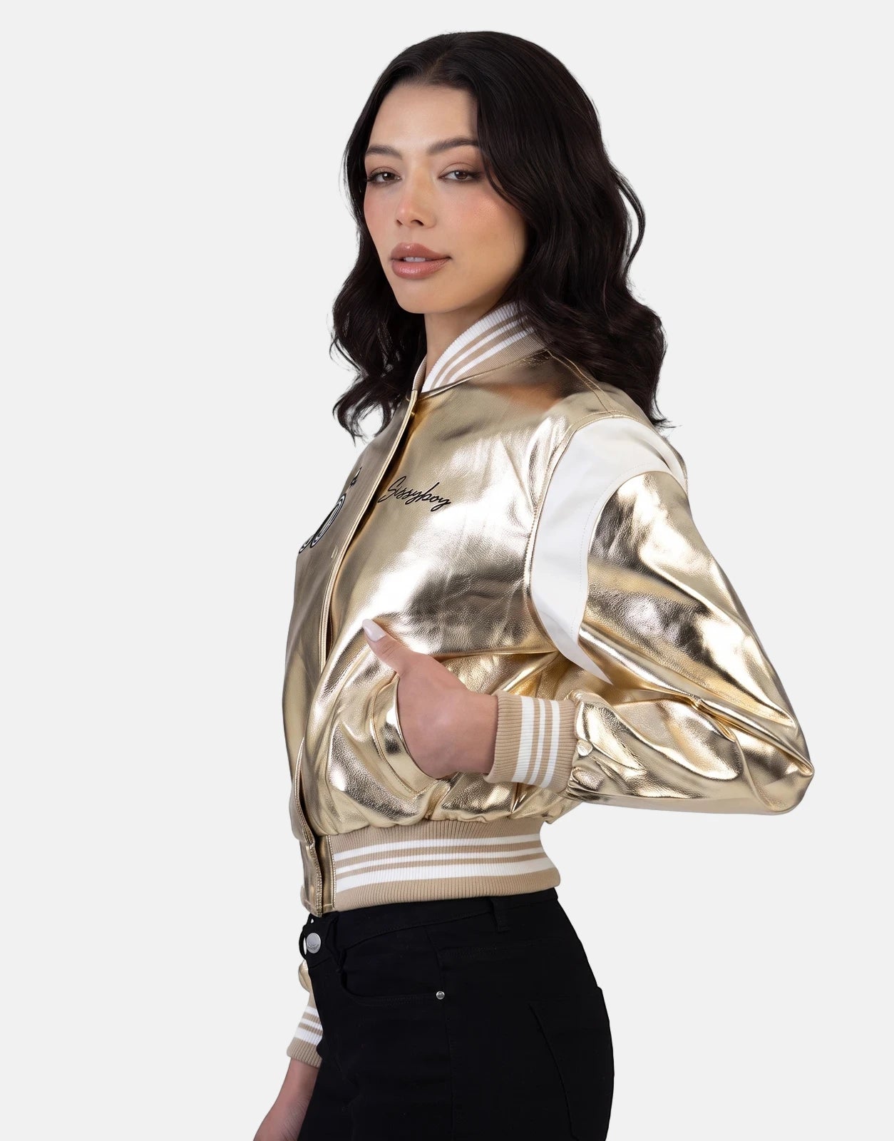 Sissy Boy Take It Easy Gold Bomber Jacket with metallic gold finish and white sleeves, worn by a woman in black jeans, in a
