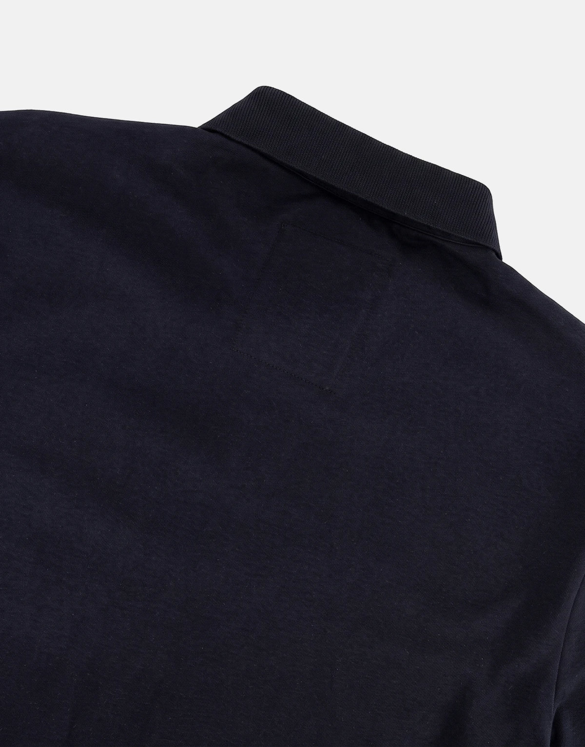 Close-up back view of a navy blue SPCC Roarke Golfer polo shirt, focusing on the ribbed collar and upper fabric.