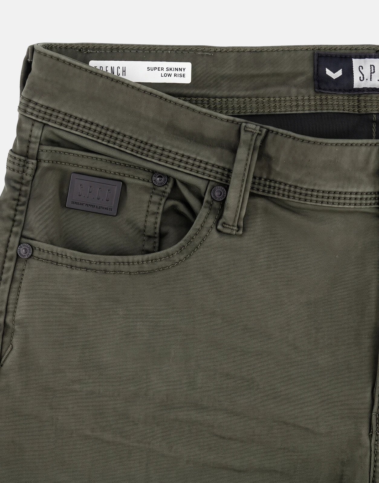 Close-up of SPCC Rodan Redrafted Fatigue Jeans, showing the dark green fabric, front pockets, and branded labels.