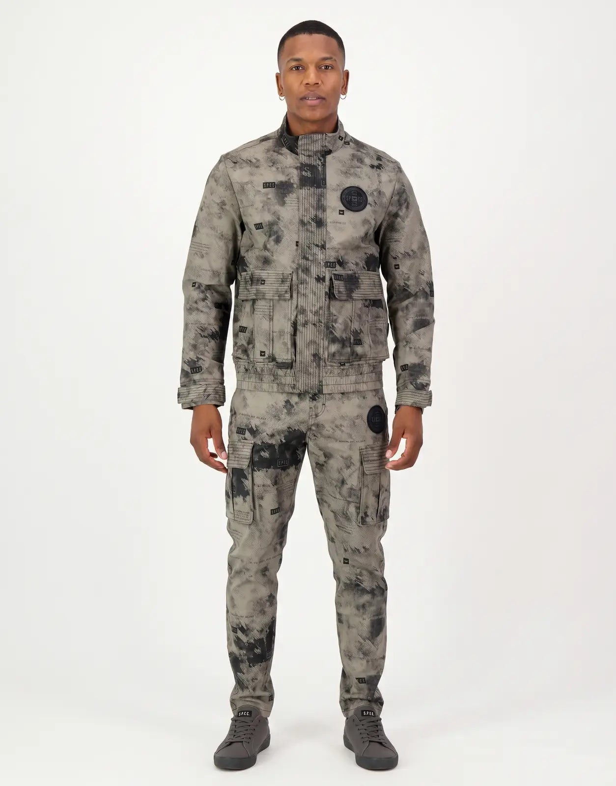 SPCC Ronan Stone Jacket for men, featuring a grey and black abstract print, multiple functional pockets, and a high collar.
