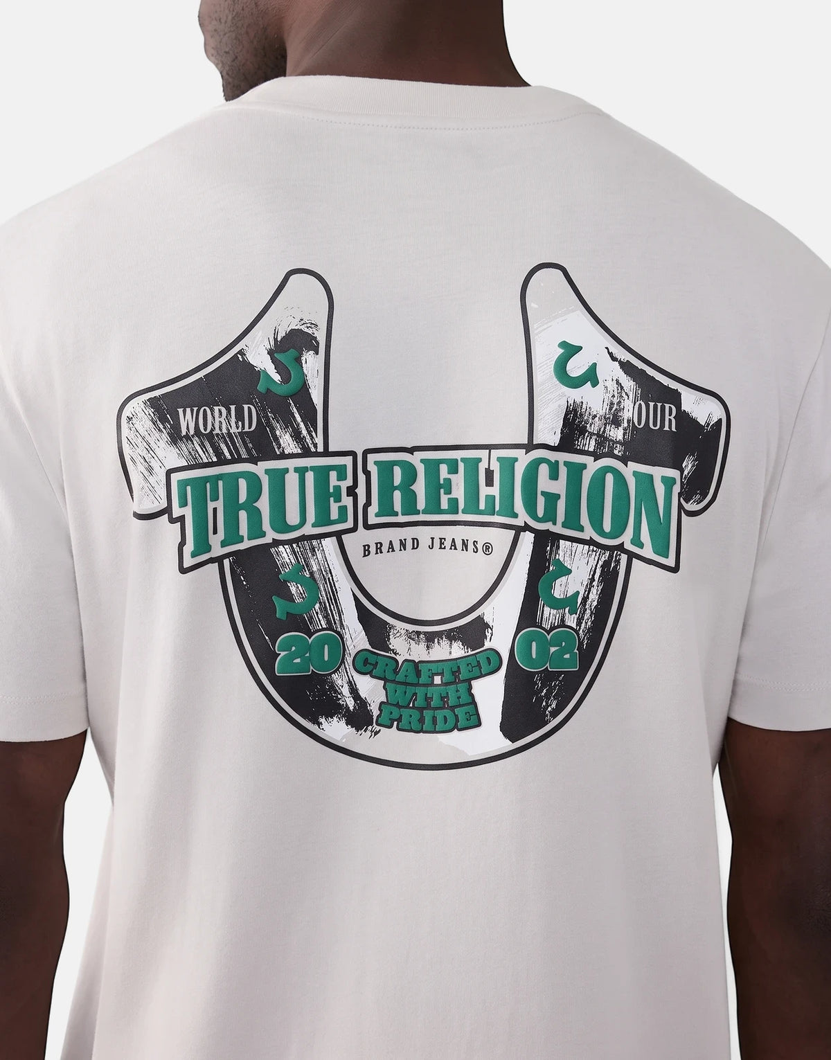 Men's True Religion Abstract Denim T-Shirt in off-white, featuring a large green and black horseshoe graphic on the back.
