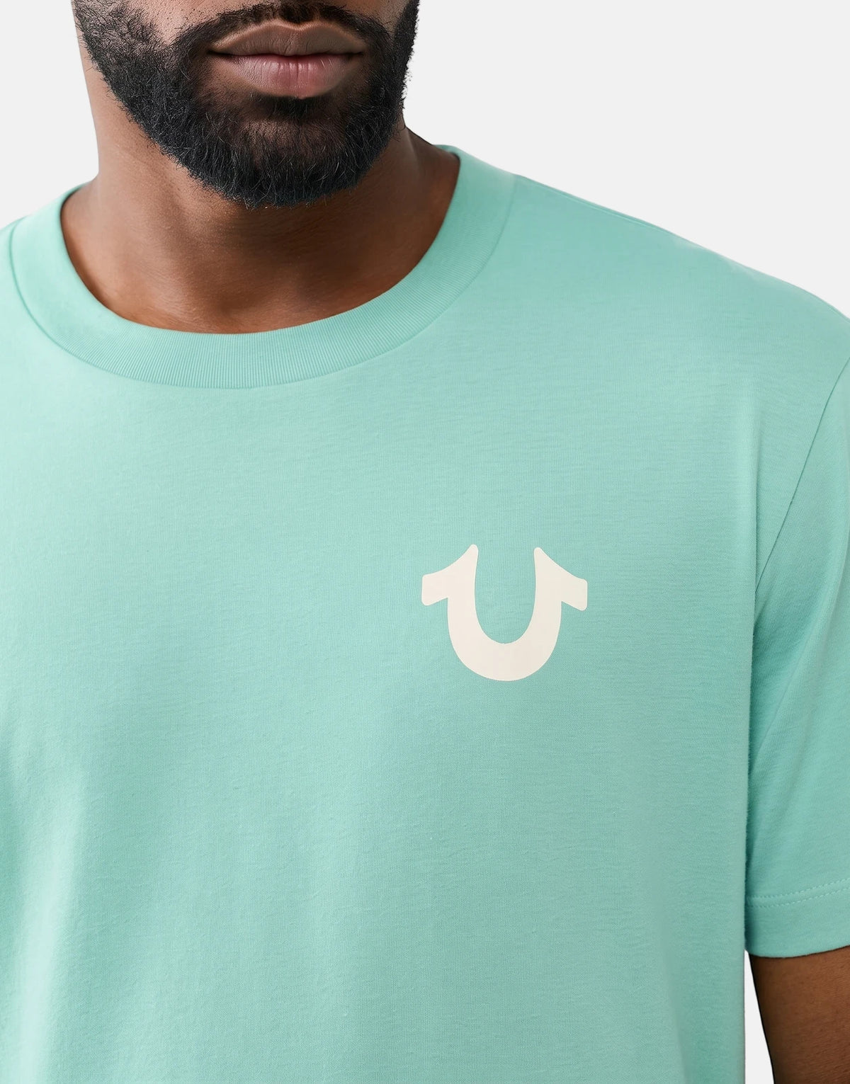 True Religion Rect Beryl Green T-Shirt with white horseshoe logo on the chest, worn by a man.