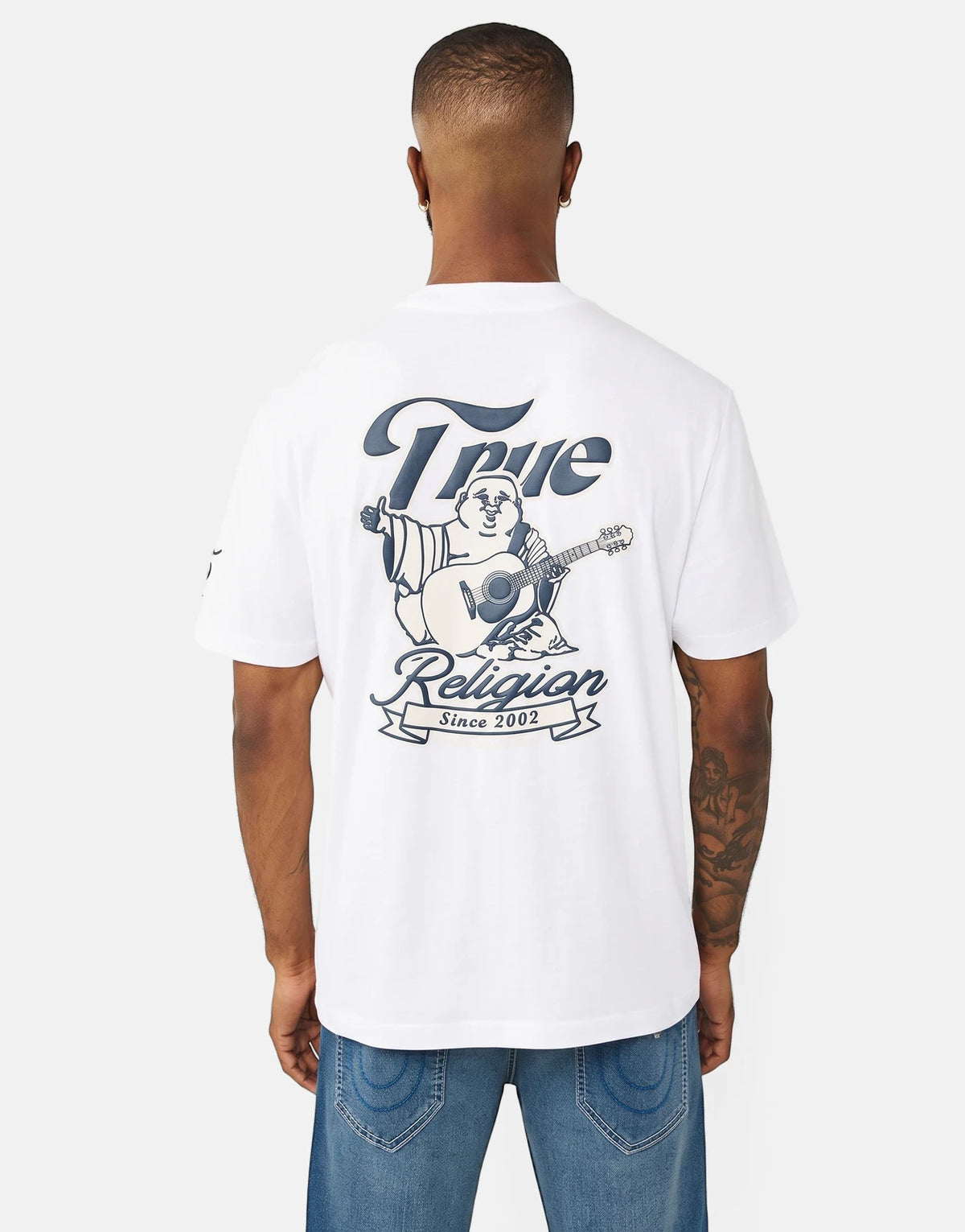 Men's True Religion Super True T-shirt in white with a Buddha playing guitar graphic on the back, shown worn by a model.